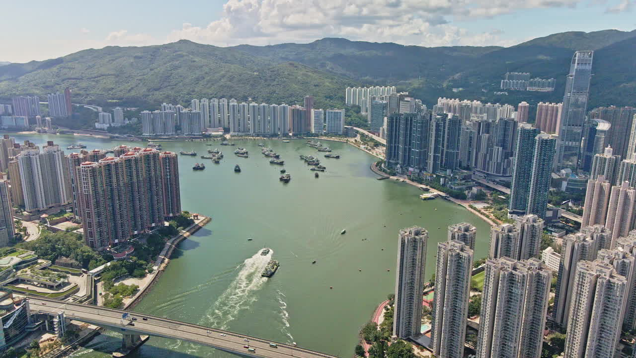 tráfico de barcos frente al mar tsuen wan con la impresionante torre nina, hong kong