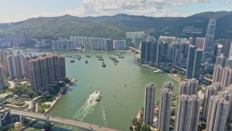 Tsuen-Wan-Waterfront-Bootsverkehr-Mit-Beeindruckendem-Nina-Tower,-Hongkong