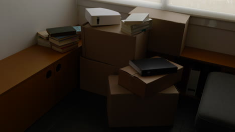 Kartons-Und-Bücher,-Die-Im-Wohninnenraum-Gestapelt-Sind,-Bereit-Für-Den-Umzugstag-Des-Hauses