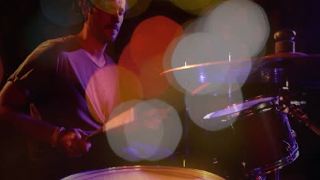 male drummer performing on dim stage, featuring music industry concept with floating bokeh lights
