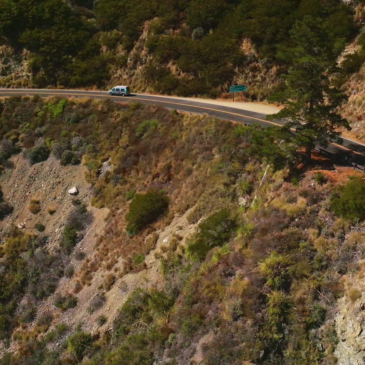 Dangerous road passing through the mountainous territory. Traffic through rocky landscape on sunny hot day