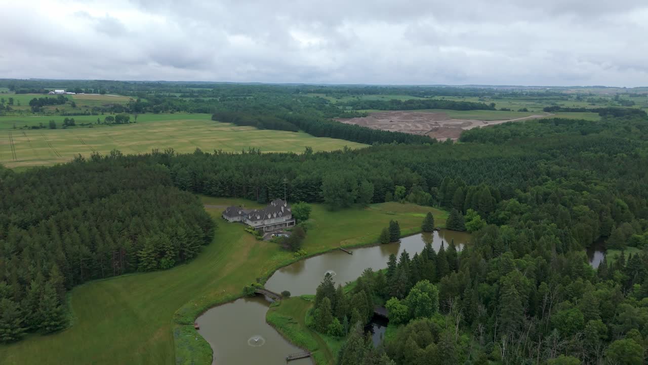 Ilmakuva yksityisestä taimenenkalastuskerhosta, jota reunustavat metsäinen maasto ja pellot rehevässä vihreässä maaseutumaisemassa.