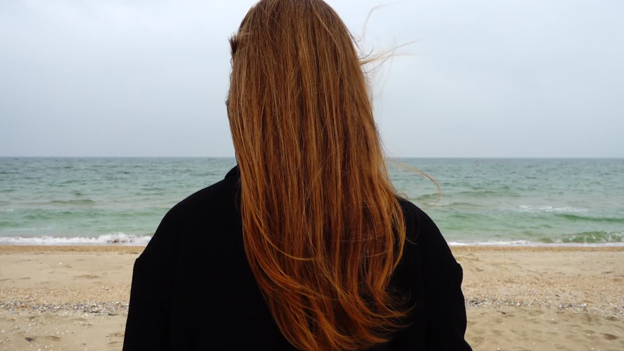La chica mira el mar. Cámara lenta. Grabación en la playa.