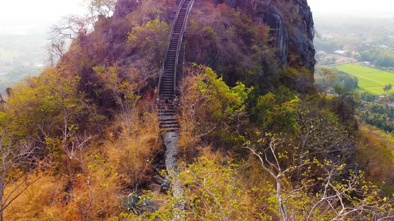Hiking through a lush colored forest to the top of a mountain with a view in Thailand