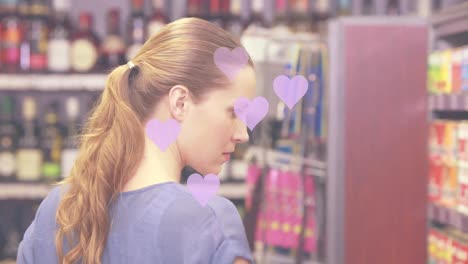 animation of falling heart icons over caucasian women in the store