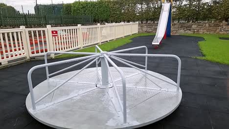 slow motion empty spinning kids playground carousel rotating in public park