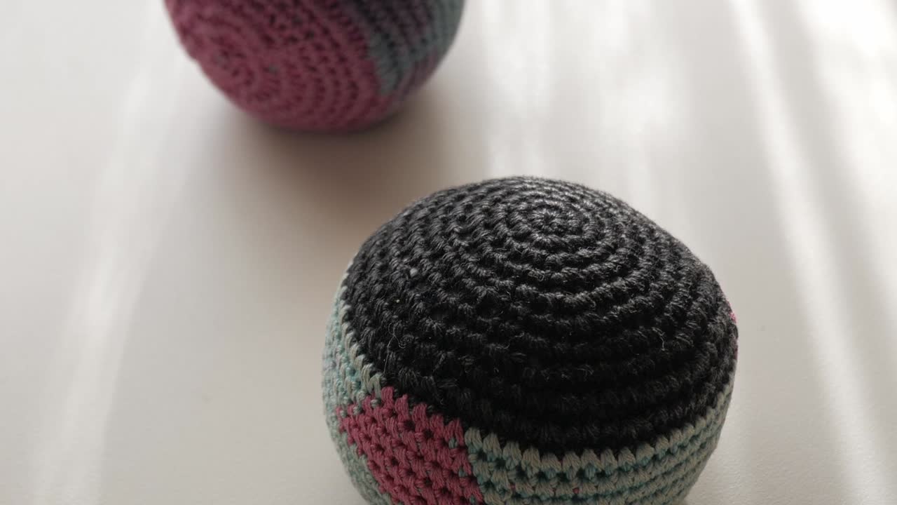 Close-up of crocheted juggling balls on a table. Forward view