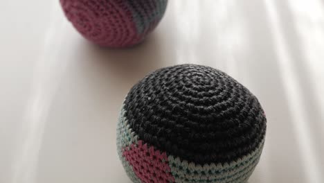 close-up of crocheted juggling balls on a table. forward view