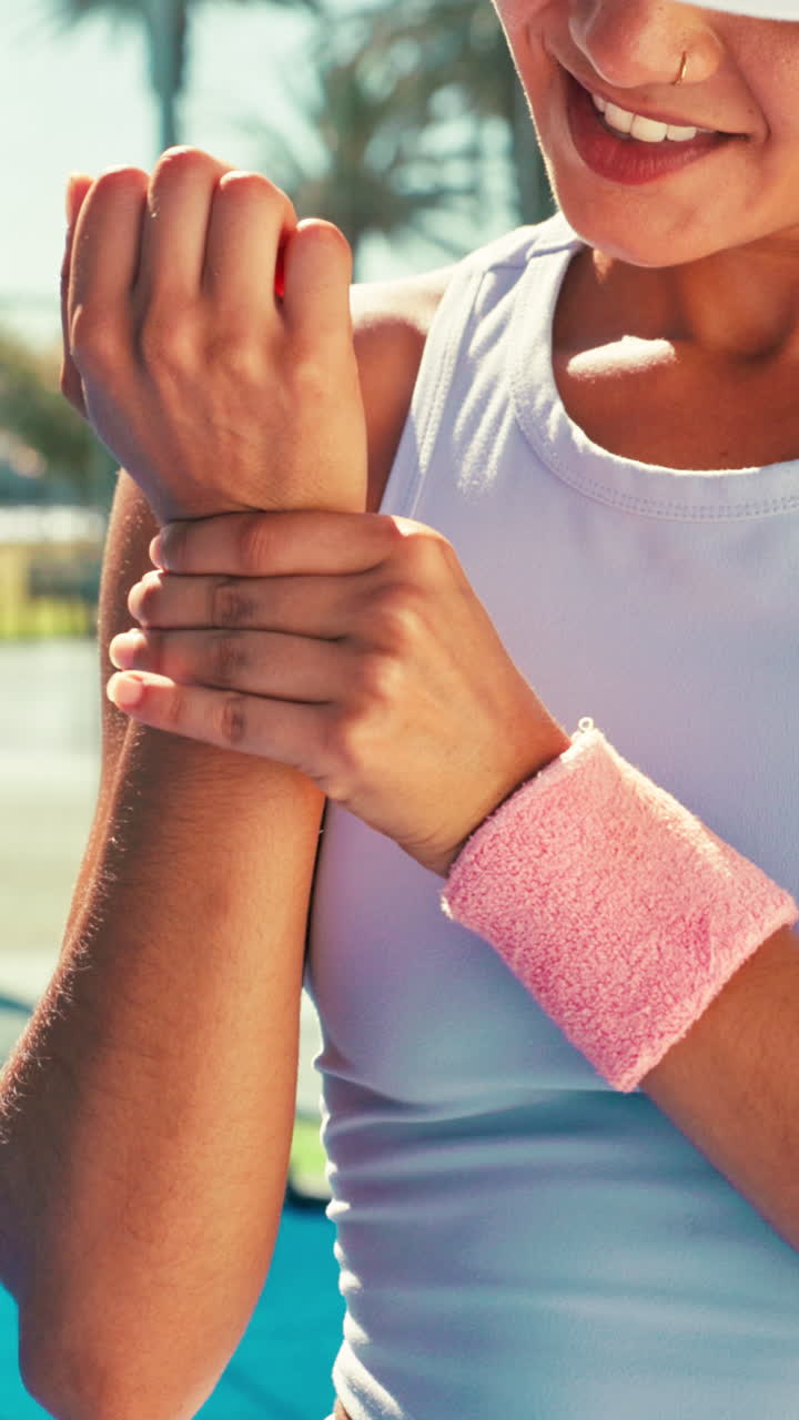 Mujer con muñequera rosa en una pista de tenis