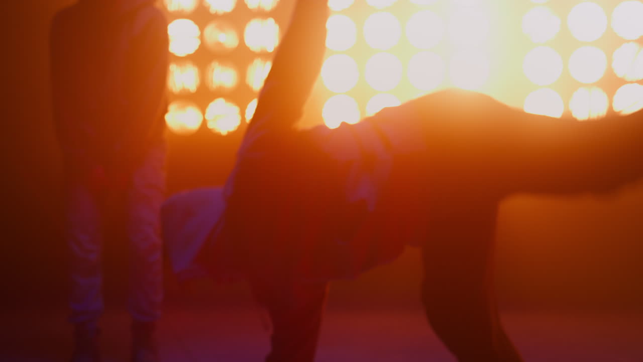 ナイトクラブで踊るブレイクダンスグループのシルエット。フリースタイルを披露するB-BOYたち。