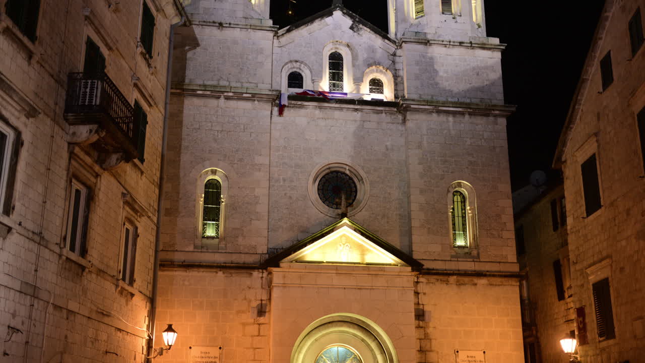 La chiesa di San Nicola illumina la città vecchia di Cattaro di notte, mostrando l'architettura tradizionale