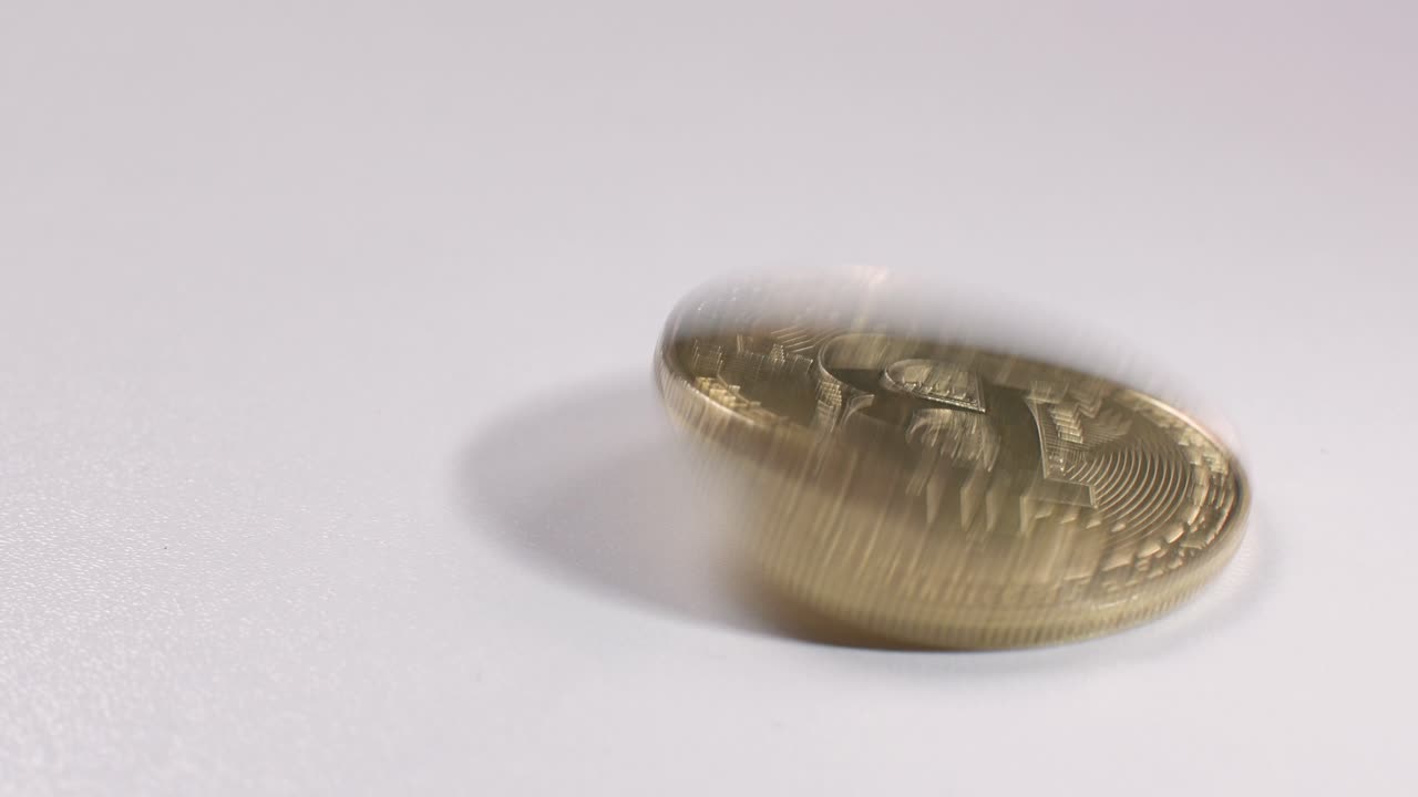 girando bitcoin en una mesa blanca