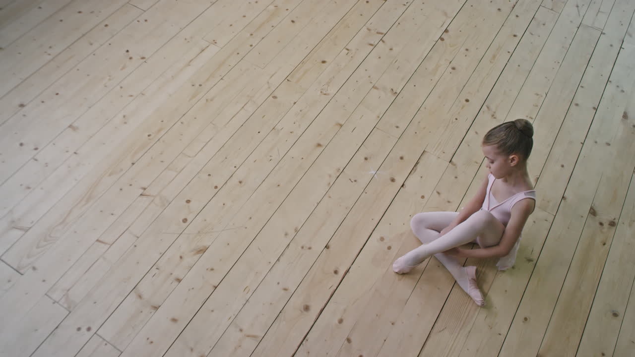 Top View Of Little Ballerina Tying Pointes