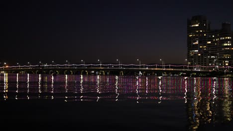 puente iluminado que se refleja en el agua por la noche