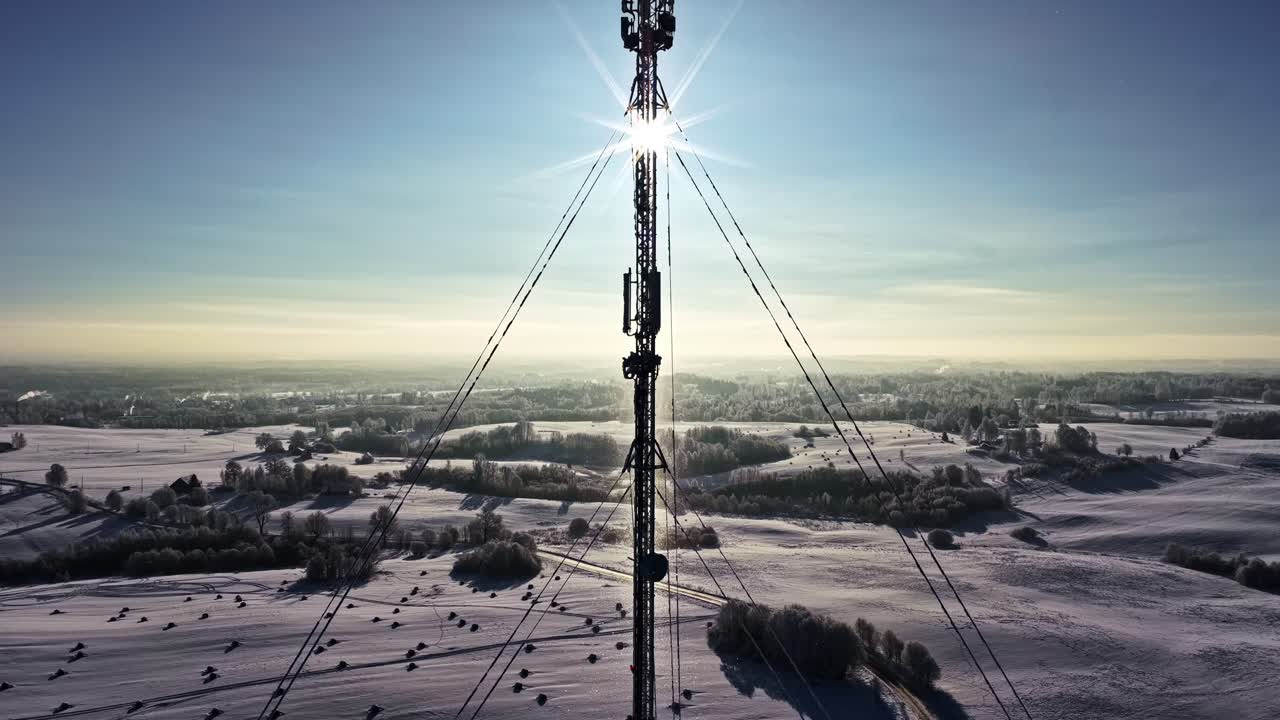Torre di telecomunicazioni che fornisce connettività wireless attraverso campi invernali innevati. Torre di rete mobile che invia segnali su una terra invernale fredda, collegando digitalmente le comunità.