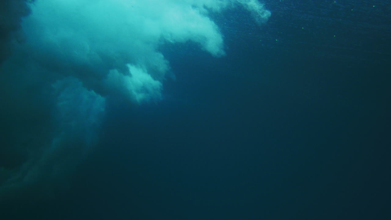 Sideview underwater of ocean wave breaking with mist and spray