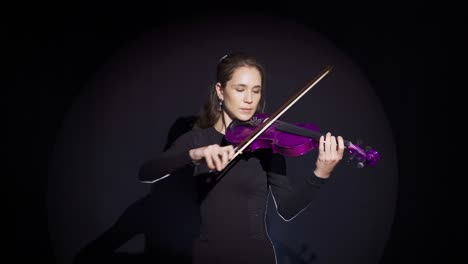 A-musician-woman-who-has-finished-playing-the-violin-on-the-stage-salutes.