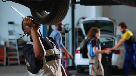 engineer inspects car on overhead lift