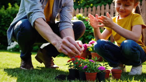 father and daughter planting flowers in the garden