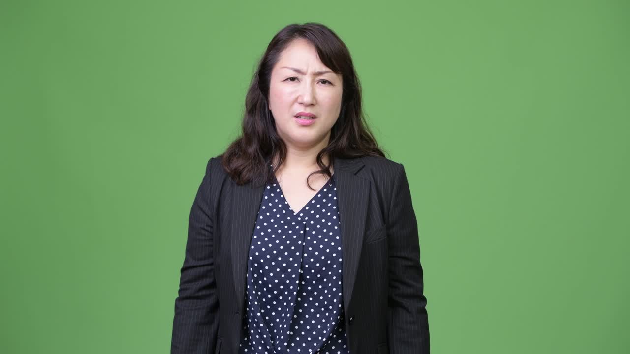 성숙하고 아름다운 아시아 사업가 여자가 어깨를 끄덕인다.