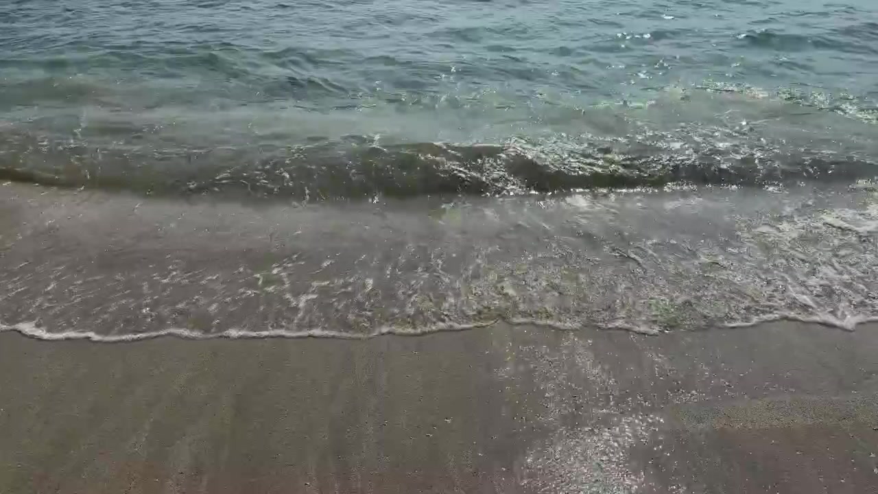 Le dolci onde dell'oceano si muovono sulla spiaggia sabbiosa