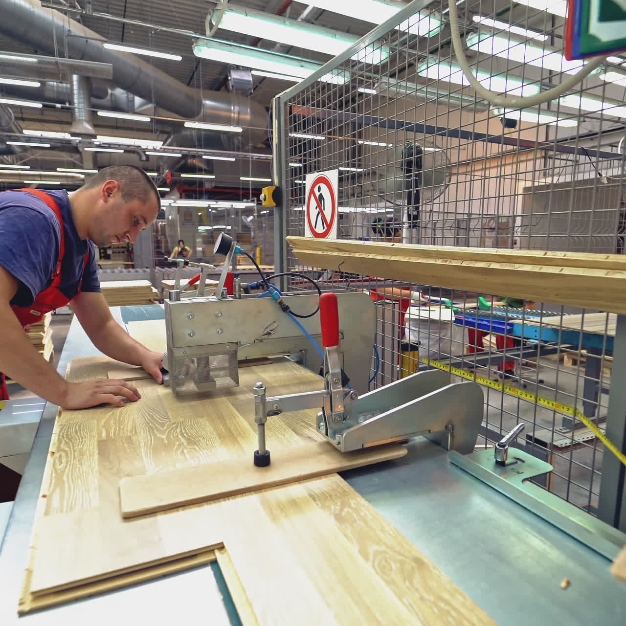 Carpenter working with Industrial tool in wood factory. Manufacture of flooring, parquet processing