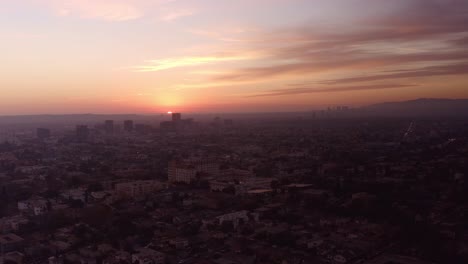 Amplia-Toma-Aérea-Del-Sol-Desapareciendo-En-El-Horizonte-En-La-Ciudad-De-Los-ángeles