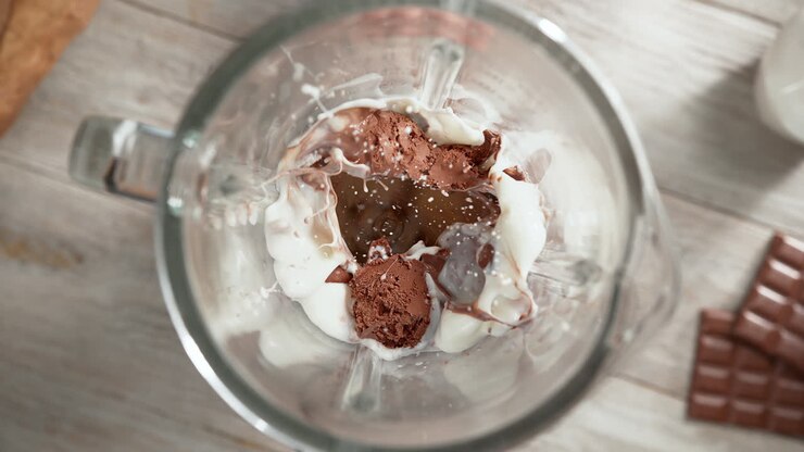 Chocolate Ice Cream Milkshake Mixed In A Glass Blender In Slow Motion, Top View, Inside of the Device