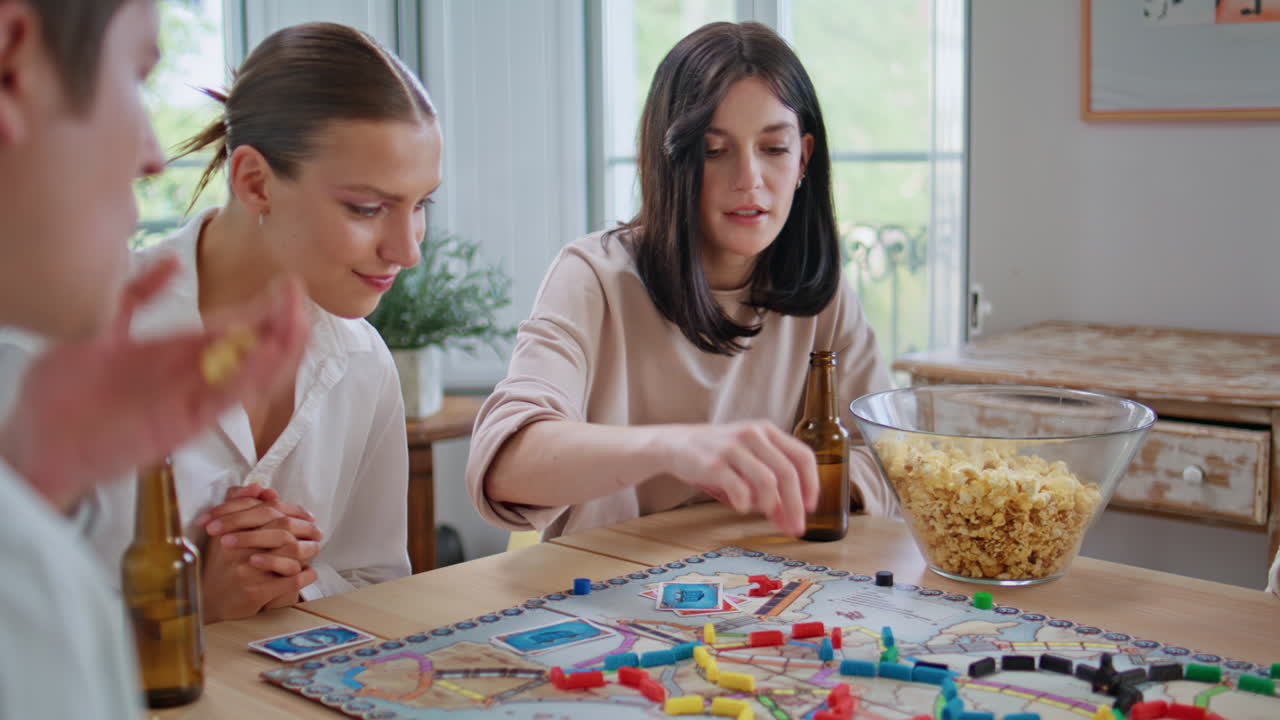 Happy buddies having party on weekends closeup. Friends playing ticket to ride