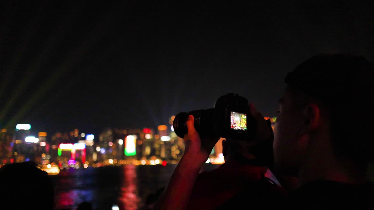 写真家が夜の街の明るい光を撮影する