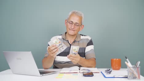 Man-looking-at-laptop-counting-money.