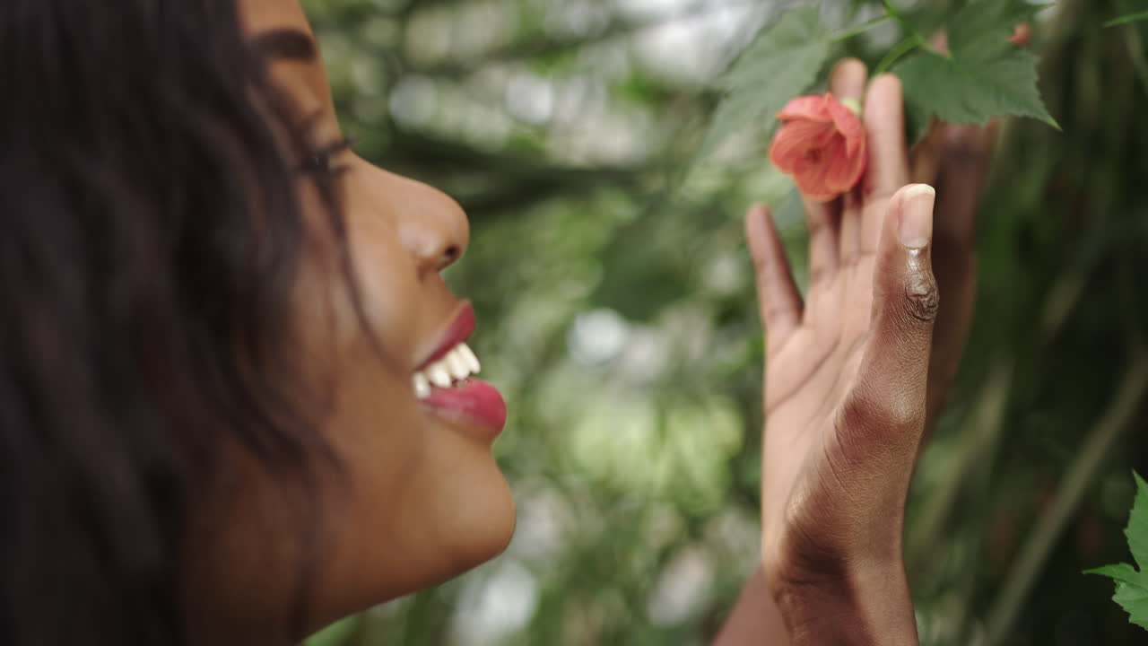 Giovane e bellissima donna afroamericana con trucco naturale nel giardino botanico della foresta pluviale