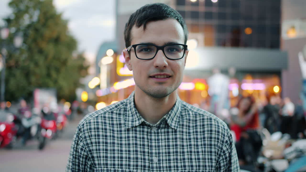 Man in a plaid shirt on a city street at night