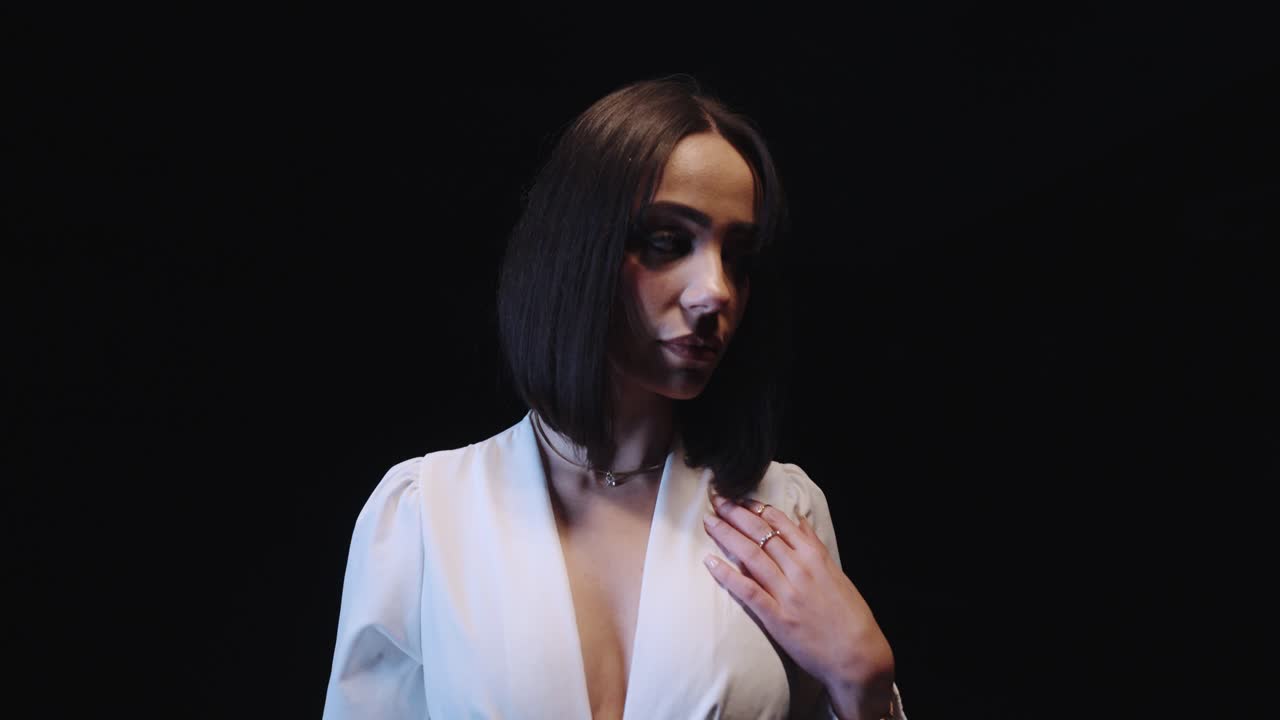 woman posing in a white outfit. black background slow motion