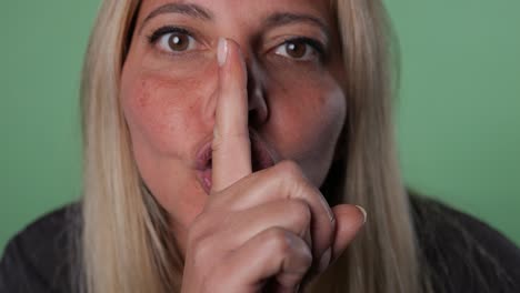 portrait of blonde mature woman making silent gesture