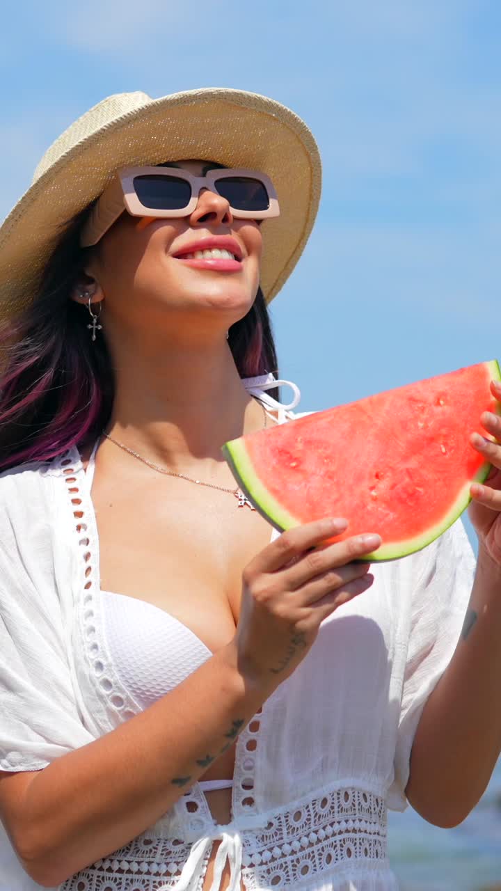 Mujer disfrutando de una sandía en la playa