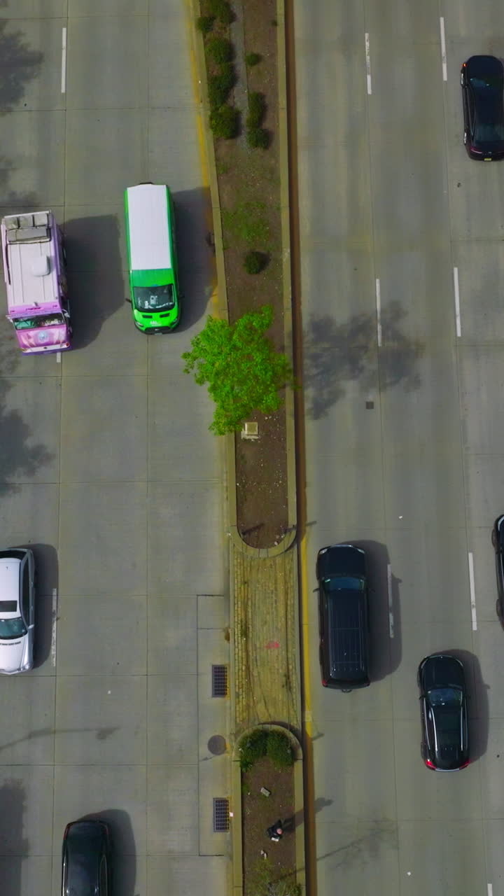 Wide road with several lanes with numerous cars driving on it. Drone footage along the busy motorway in New York. Vertical video