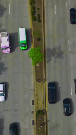 wide road with several lanes with numerous cars driving on it. drone footage along the busy motorway in new york. vertical video