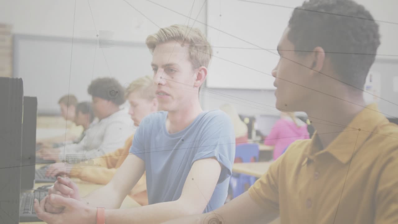 Male student in blue t-shirt glancing neighbor and asking for help with monitors in computer class