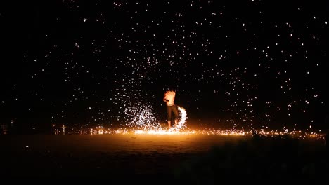 performer displays fire skills on the beach