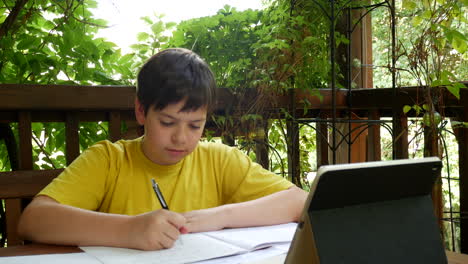 niño haciendo la tarea en el balcón