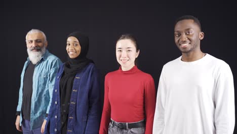 group of people of different races looking at camera on black background and are happy.