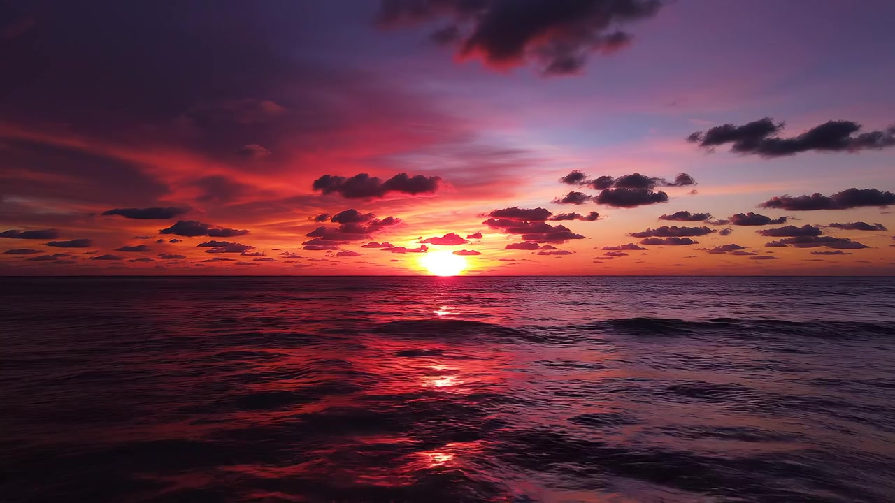 Levende havsolnedgang med dramatisk lilla og orange himmel