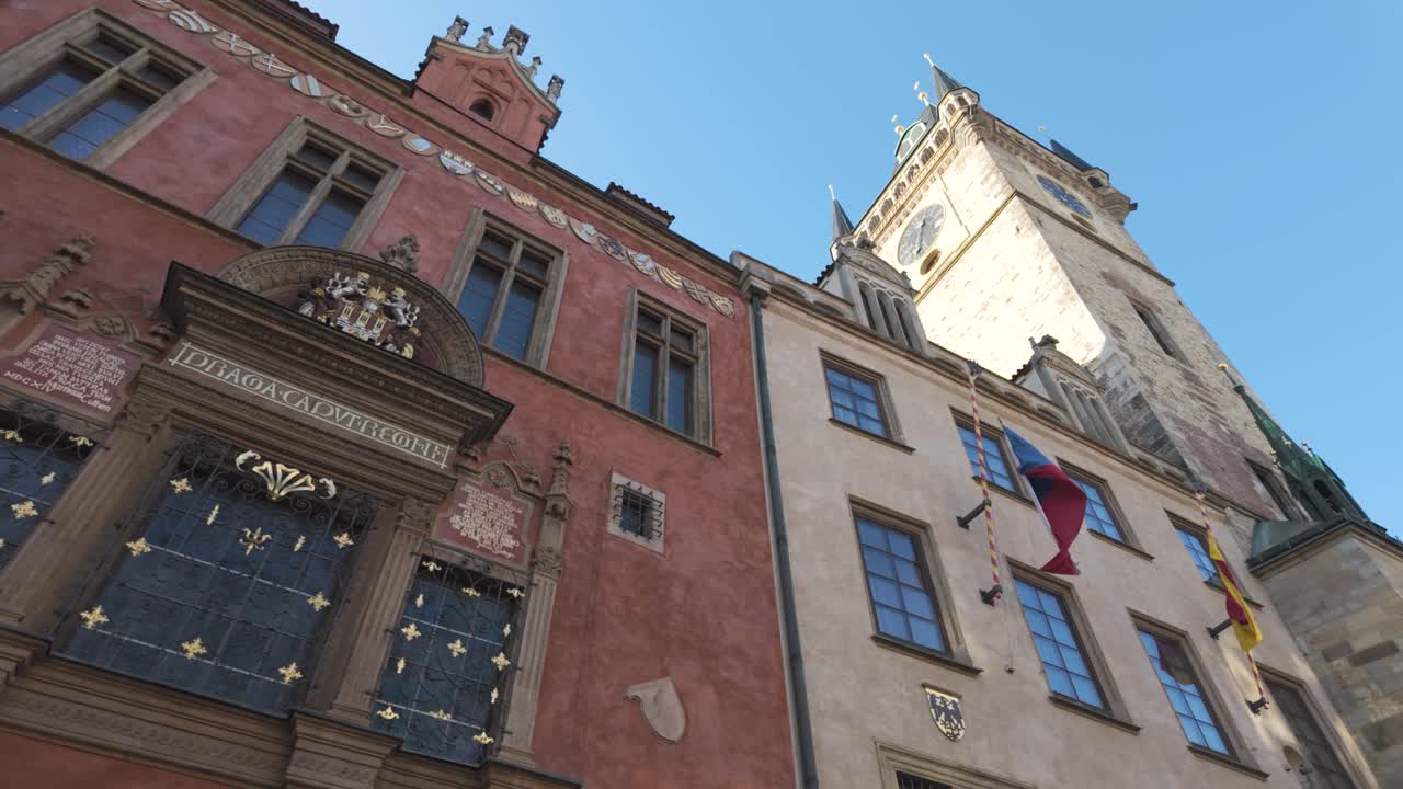 The famous Astronomical Clock Tower in Prague under a clear blue sky, shot from a low angle