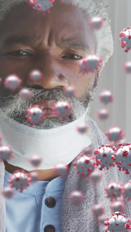 animation of virus cells over senior african american man with face mask