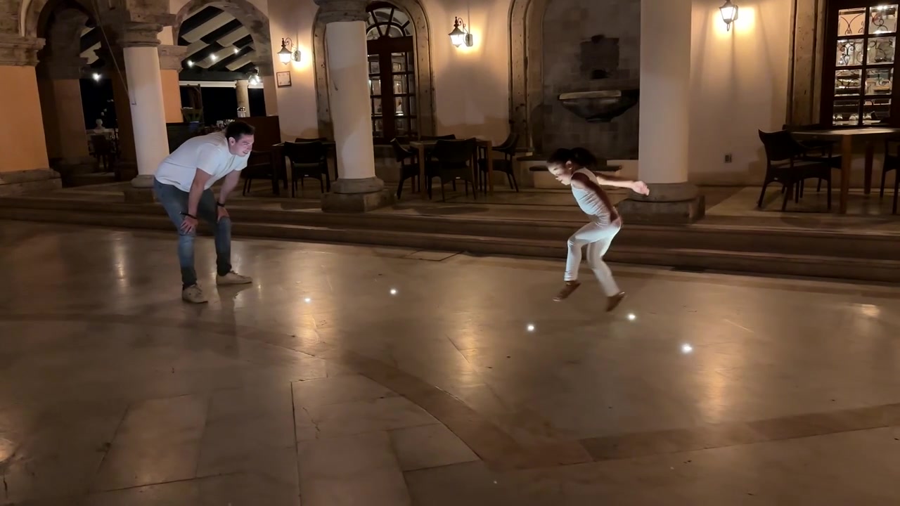 Lo zio guarda la giovane nipote giocare e saltare nel cortile del resort in vacanza.