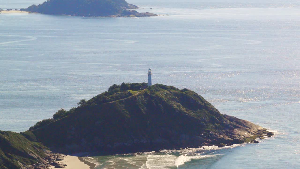 Ilha do Mel island's lighthouse mountain on rocky hill surrounded by ocean waters, Paraná, Brazil