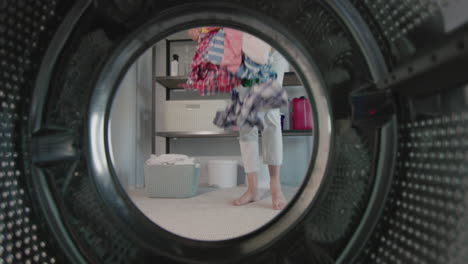 a woman dumps laundry on the floor