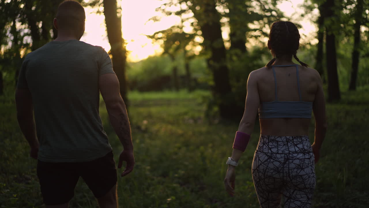 Couple running in the forest at sunset