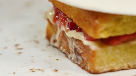 close-up of a piece of layered cake with strawberries and white icing